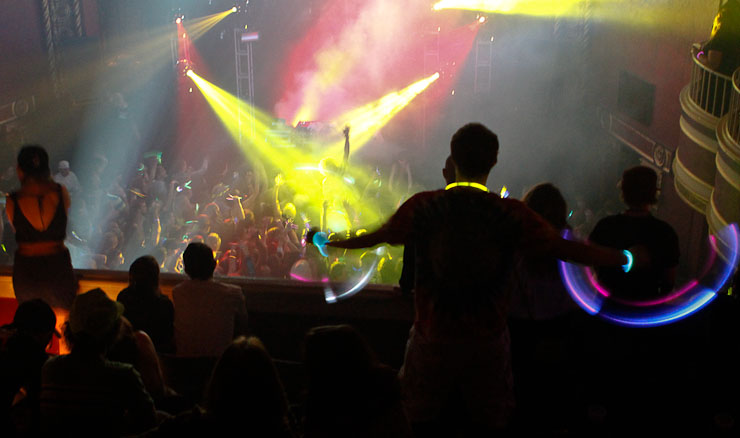 Fans wave glow sticks on the balcony of the Blue Note at the start of the Bassnectar concert, fashioned to be like a rave party.